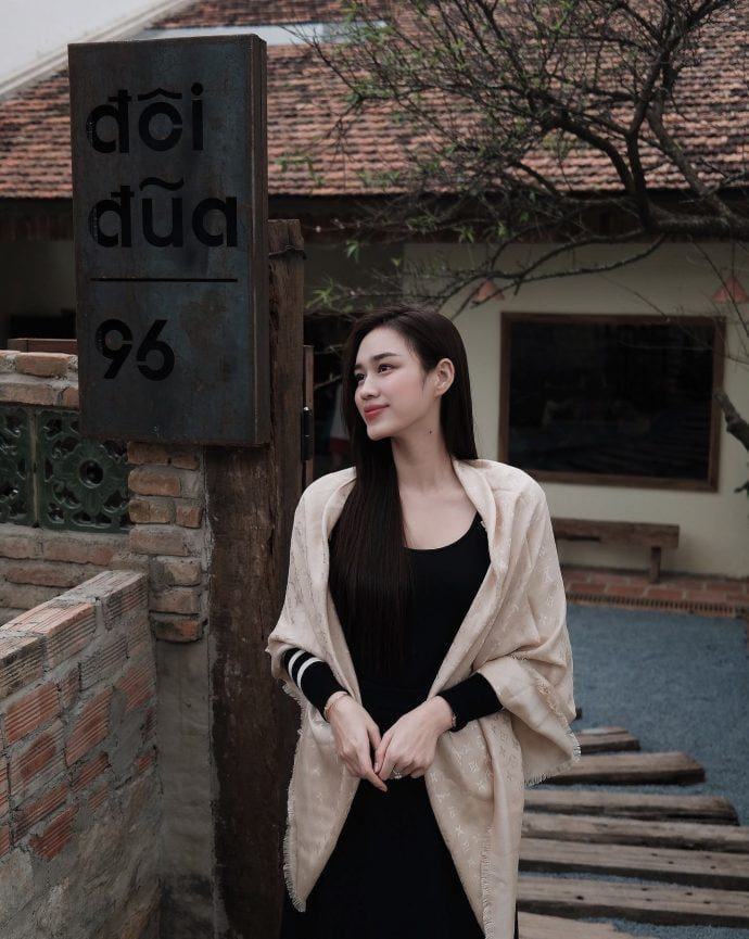 Đỗ Thị Hà diện váy đen và khăn choàng, phong cách nữ tính và bay bổng.