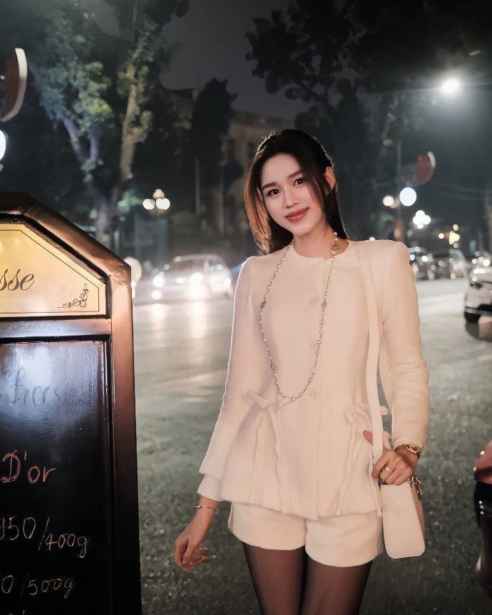 Đỗ Thị Hà mix áo sơ mi xanh pastel, cardigan trắng và quần jeans.